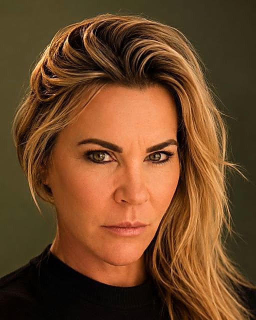 Raquel, the studio's practitioner, photographed against a deep olive backdrop